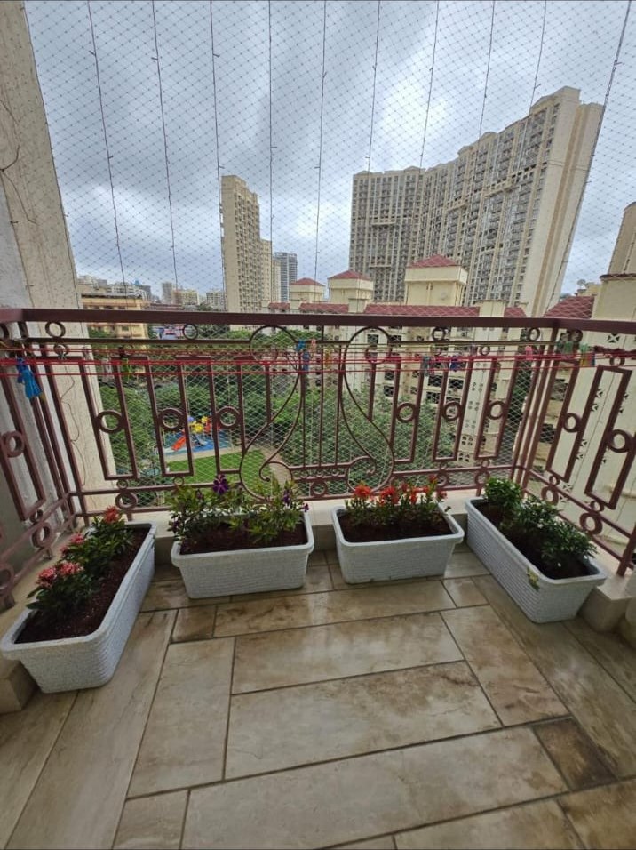 Flowering plants in white planters on a residential balcony